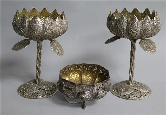 An Indian white metal footed bowl and a pair of white metal lotus shaped decorated cups.